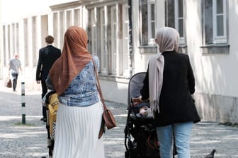 Zwei Frauen tragen ein Kopftuch: Ein Drittel der Migranten in NRW spricht zu Hause nur Deutsch.