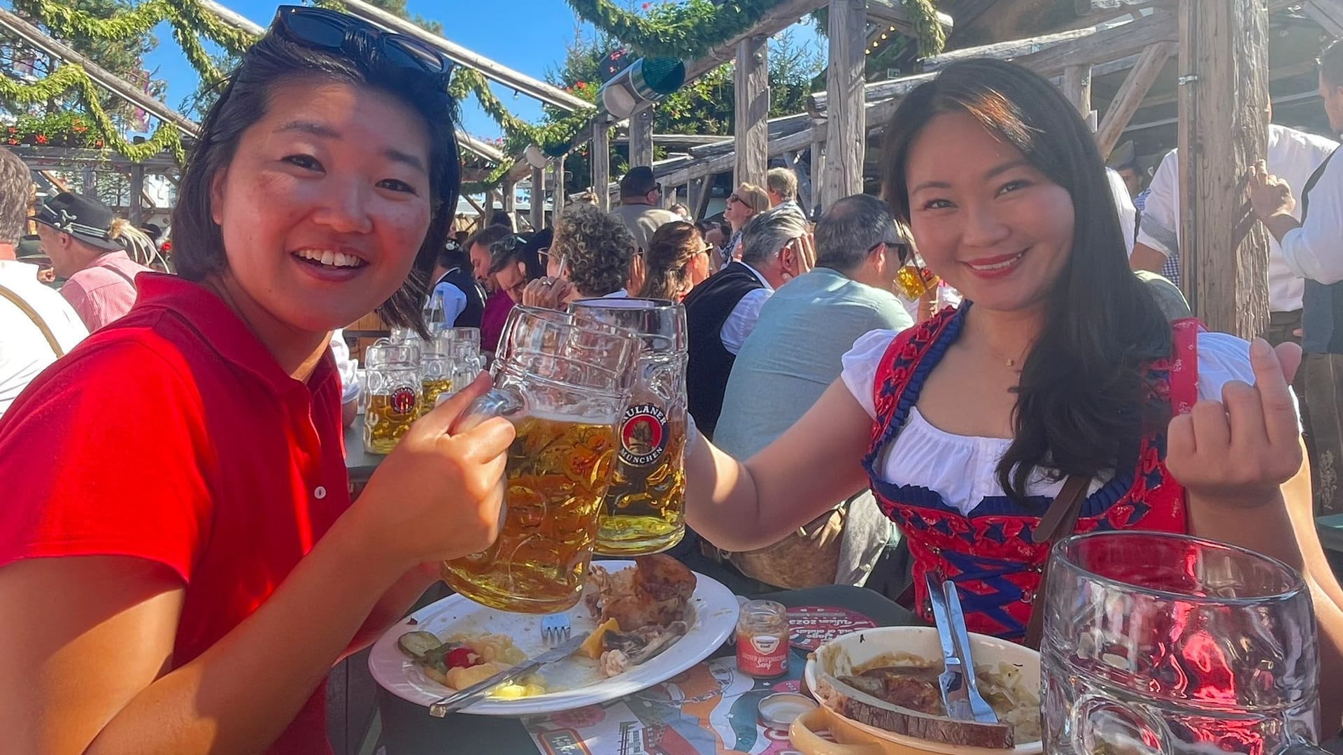 Die zwei Touristen prosten sich mit ihrer Maß zu: Sie sind vom Oktoberfest überwältigt.