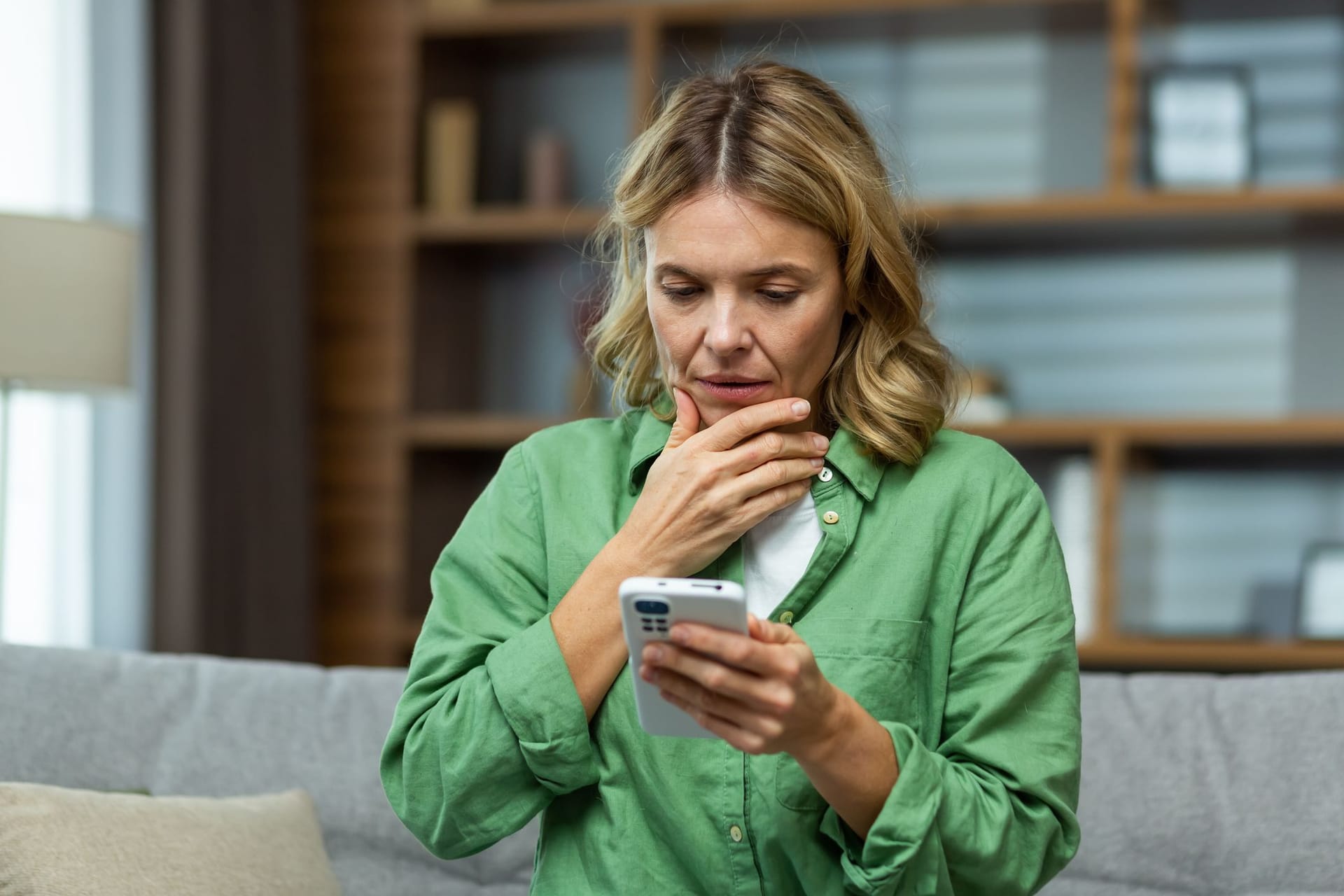 Ältere Frau blickt besorgt auf ihr Handy (Symbolbild): Was bedeutet ein Hinzuverdienst während der Rente für die Steuer?