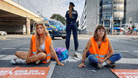 Polizistin und Klimaaktivisten der "Letzten Generation" auf der Straße