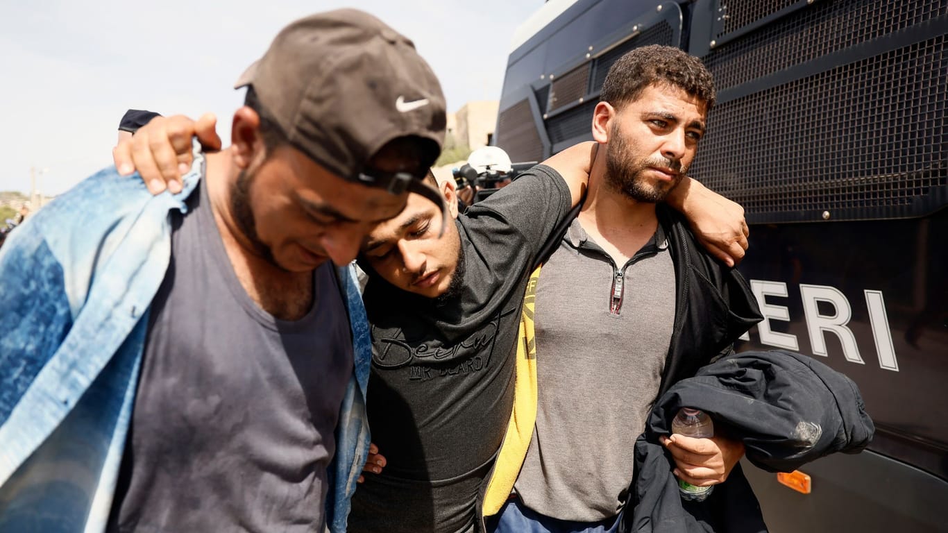 Lampedusa: Migranten helfen sich gegenseitig, als sie ein überfülltes Aufnahmezentrum verlassen.