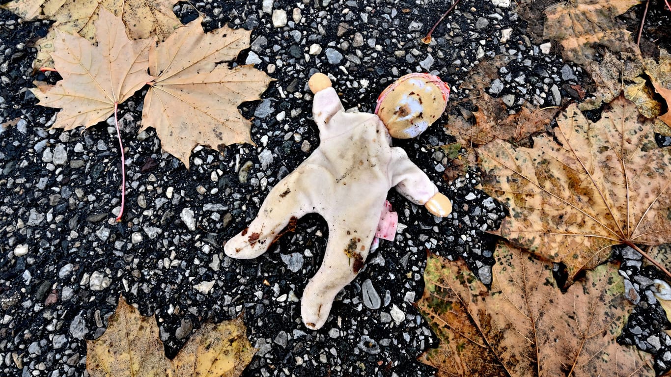Eine verlorene Kinderpuppe auf dem nassen Boden im Herbstlaub (Symbolfoto): Im Südwesten hat es noch nie so viele Kindeswohlgefährdungen gegeben wie im Jahr 2022.