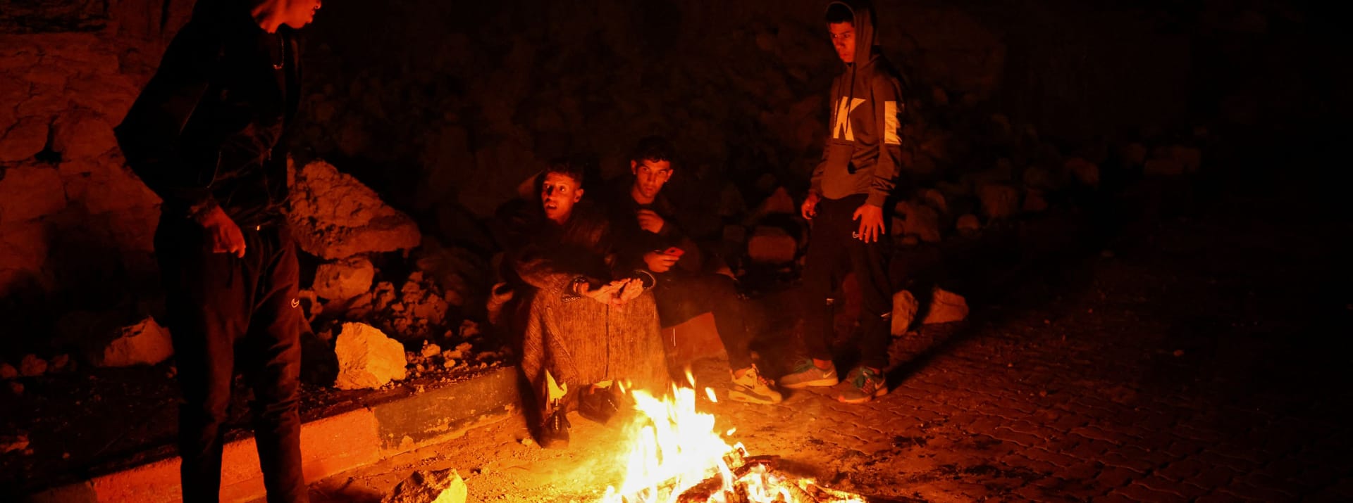Menschen sitzen in Moulay Brahim um ein Feuer herum: Auch die zweite Nacht nach dem Erdbeben, verbrachten viele Menschen im Freien.