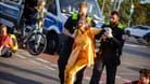 Blockade der "Letzten Generation": Die Polizei befördert eine Aktivistin von der Straße.