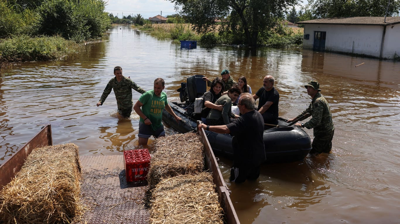 Menschen retten sich auf ein Schlauchboot in Griechenland: Nach Überschwemmungen besteht dort Seuchengefahr.