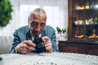 Rentner blickt in sein Portemonnaie (Symbolbild): Auf den Grundrentenzuschlag wird Einkommen angerechnet.