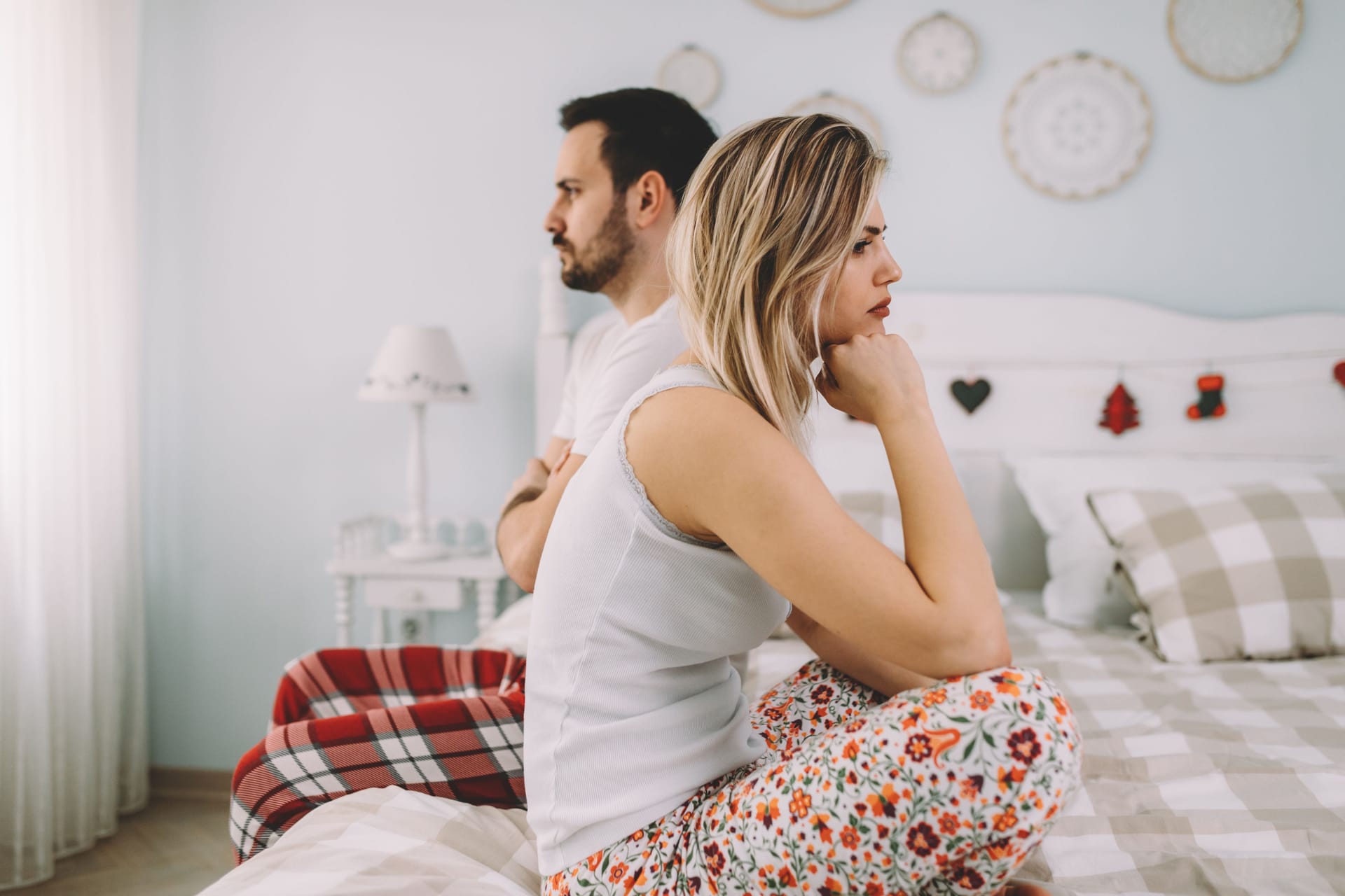 Ein missgestimmtes Paar sitzt auf dem Bett