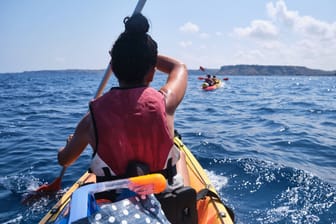 Eine Frau beim Kayaken auf dem Meer (Symbolbild): Bei starken Strömungen ist das Paddeln besonders schwierig. Das musste auch ein Kayaker in Spanien erfahren.