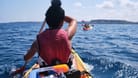 Eine Frau beim Kayaken auf dem Meer (Symbolbild): Bei starken Strömungen ist das Paddeln besonders schwierig. Das musste auch ein Kayaker in Spanien erfahren.