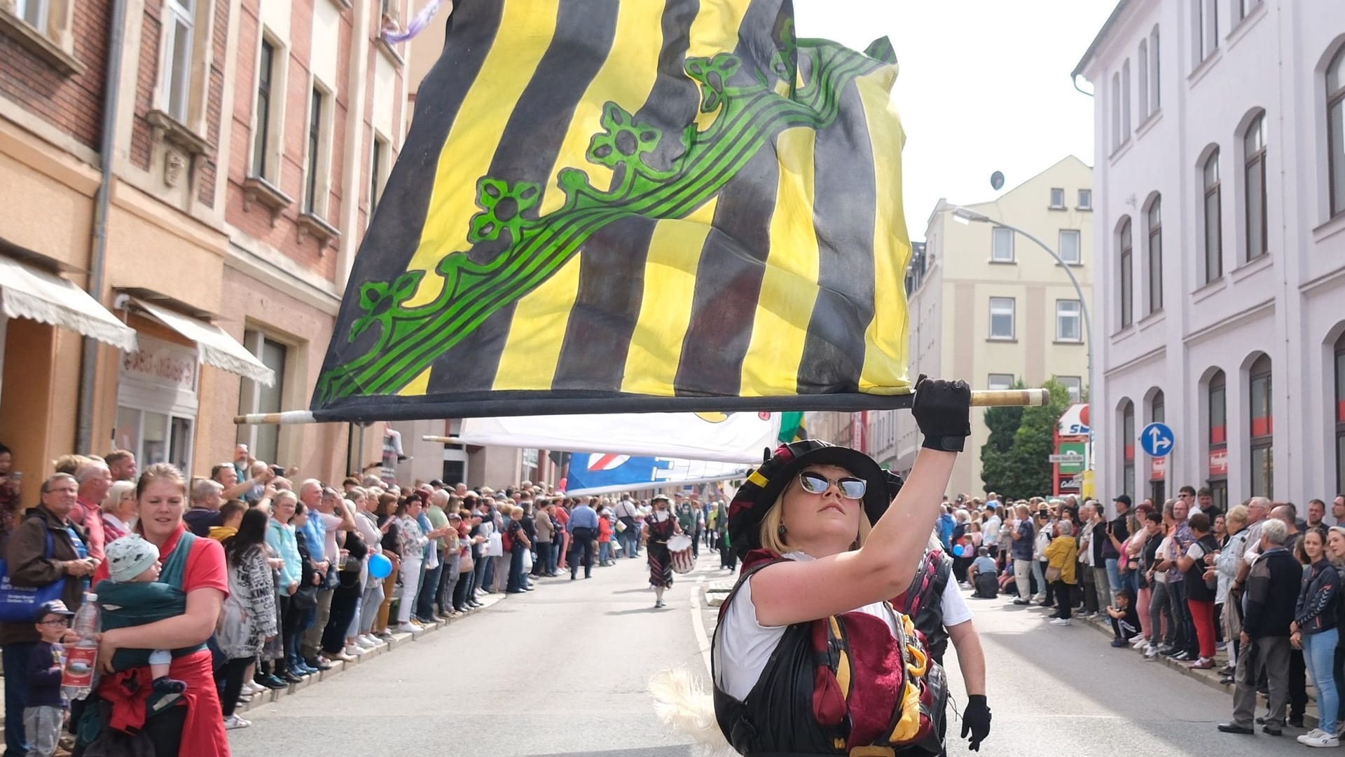 Fahnenschwinger schreiten beim Festumzug zum Tag der Sachsen durch das Stadtzentrum von Aue-Bad Schlema: Fahnenschwinger schreiten beim Festumzug zum Tag der Sachsen durch das Stadtzentrum von Aue-Bad Schlema: