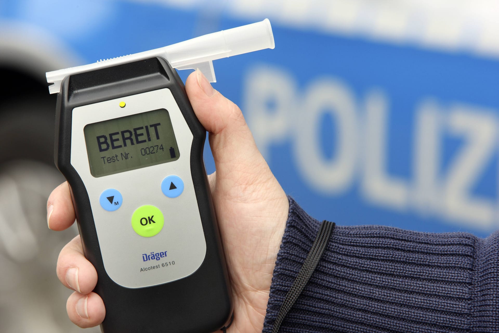 Polizist mit Atemalkohol Testgerät (Symbolbild): Seine Ausrede kauften die Beamten dem Mann nicht ab.