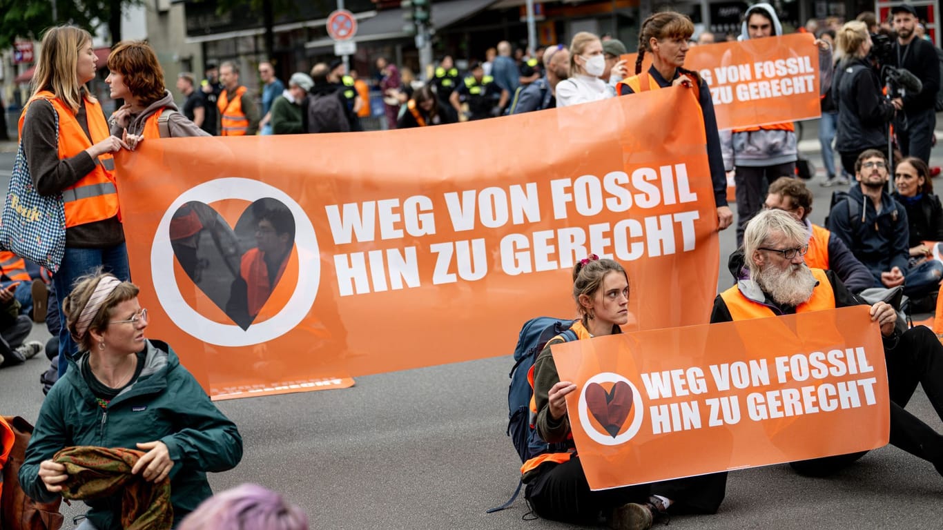 Teilnehmer einer Demonstration der Klimaschutzgruppe Letzte Generation sitzen auf der Potsdamer Straße.