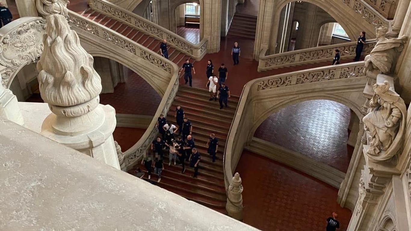 Zuschauer werden aus dem Gerichtsgebäude geführt: Schreie hallten durch das Treppenhaus in Moabit.