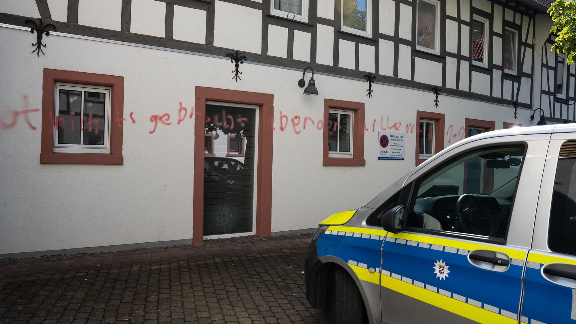 Polizeiauto vor einem mit Graffiti bemalten Gebäude: Zuerst hatte der Mann ein Gebäude in Reinheim beschmiert.