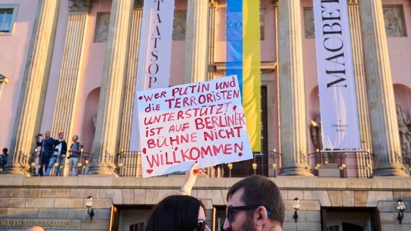 "Wer Putin und die Terroristen unterstützt ist auf Berliner Bühne nicht willkommen!" steht auf einem Plakat, das eine Demonstrantin vor der Staatsoper Unter den Linden hält. Zur Aufführung "Macbeth" mit Netrebko findet ein Protest gegen den Auftritt statt.