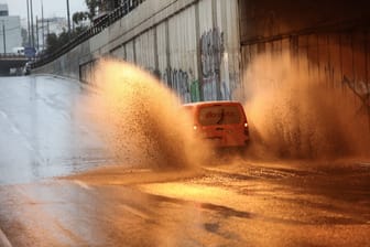 Transporter fährt durch eine von Regen überflutete Straße (Symbolfoto): Der Herbst bringt in Europa wieder starke Schauer mit sich.