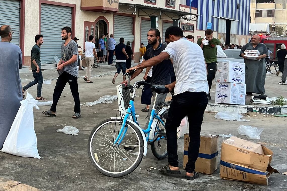 Palästinenser tragen Lebensmittelvorräte aus einem Lager der UNRWA.