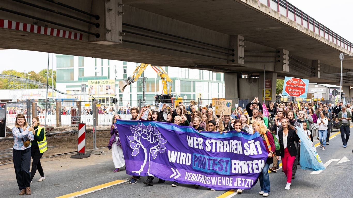 Hannover: Teilnehmer einer Demonstration gegen den Ausbau des Südschnellwegs in der Leinemasch, laufen parallel zur Brücke vom Südschnellweg in Hannover.