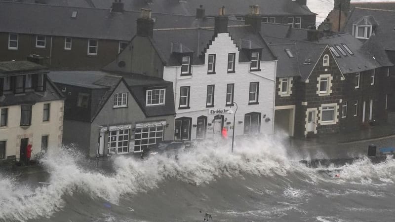 Schottische Nordseeküste: Hohe Wellen brechen an einer Kaimauer.