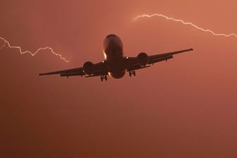 Blitze über einem Flugzeug in Hessen (aufgehelltes Symbolfoto): Experten halten Blitzeinschläge in Flugzeugen für ungefährlich.