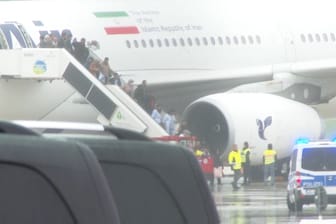 Passagiere des betroffenen Flugzeugs verlassen sie Maschine. Der Flieger wurde in einem Sonderbereich gebracht.