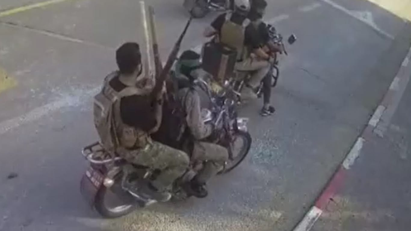Bewaffnete Hamas-Terroristen fahren auf Motorrädern durch einen Kibbuz in der Nähe des Gazastreifens.