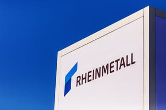 Gepanzertes Fahrzeug vor dem Logo von Rheinmetall (Symbolbild): Die Rheinmetallaktie profitiert von der Eskalation im Nahen Osten.