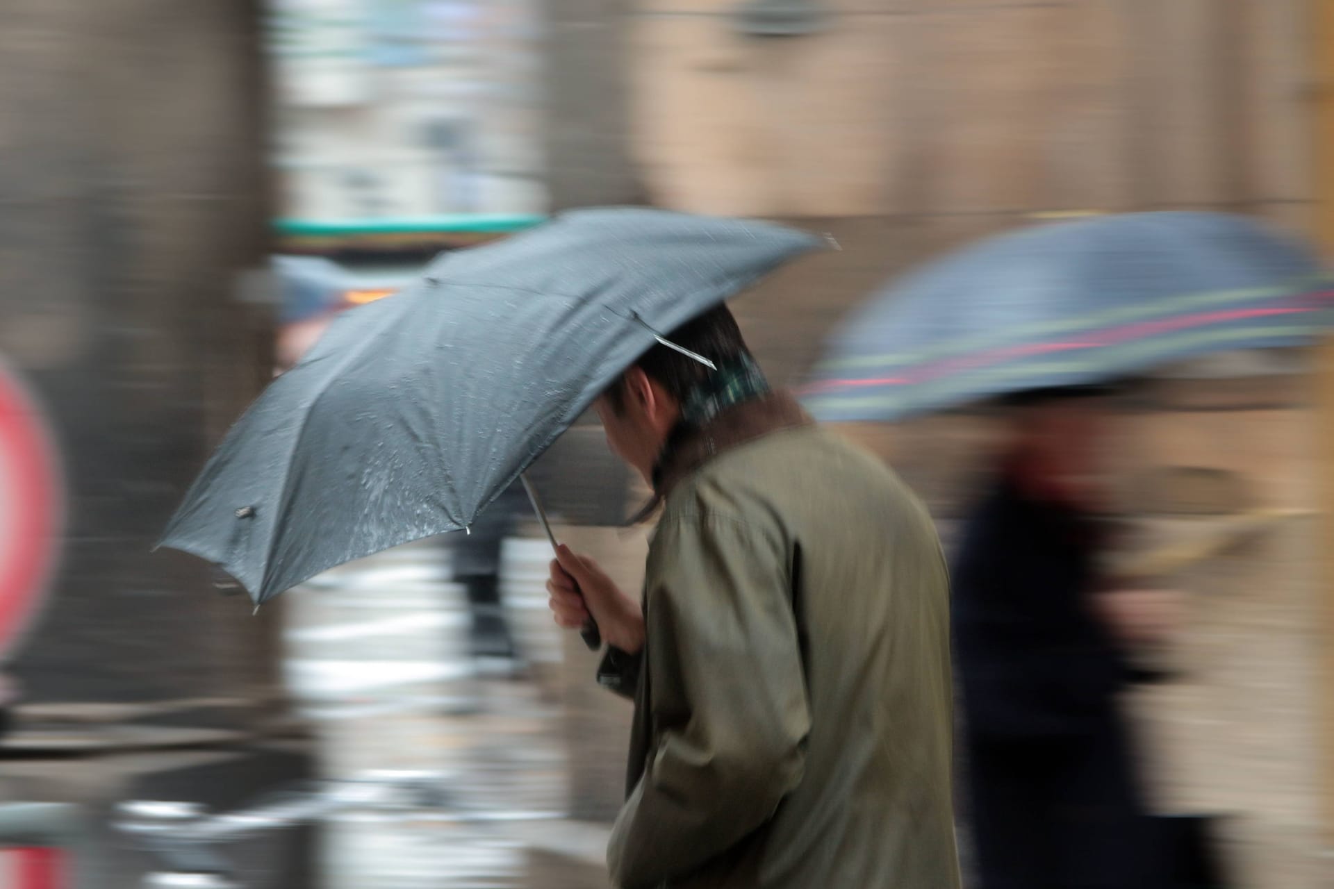 Ein Mann mit Regenschirm läuft über den Münchner Marienplatz (Archivbild): Das Wochenende im Süden und Südwesten droht ungemütlich zu werden.