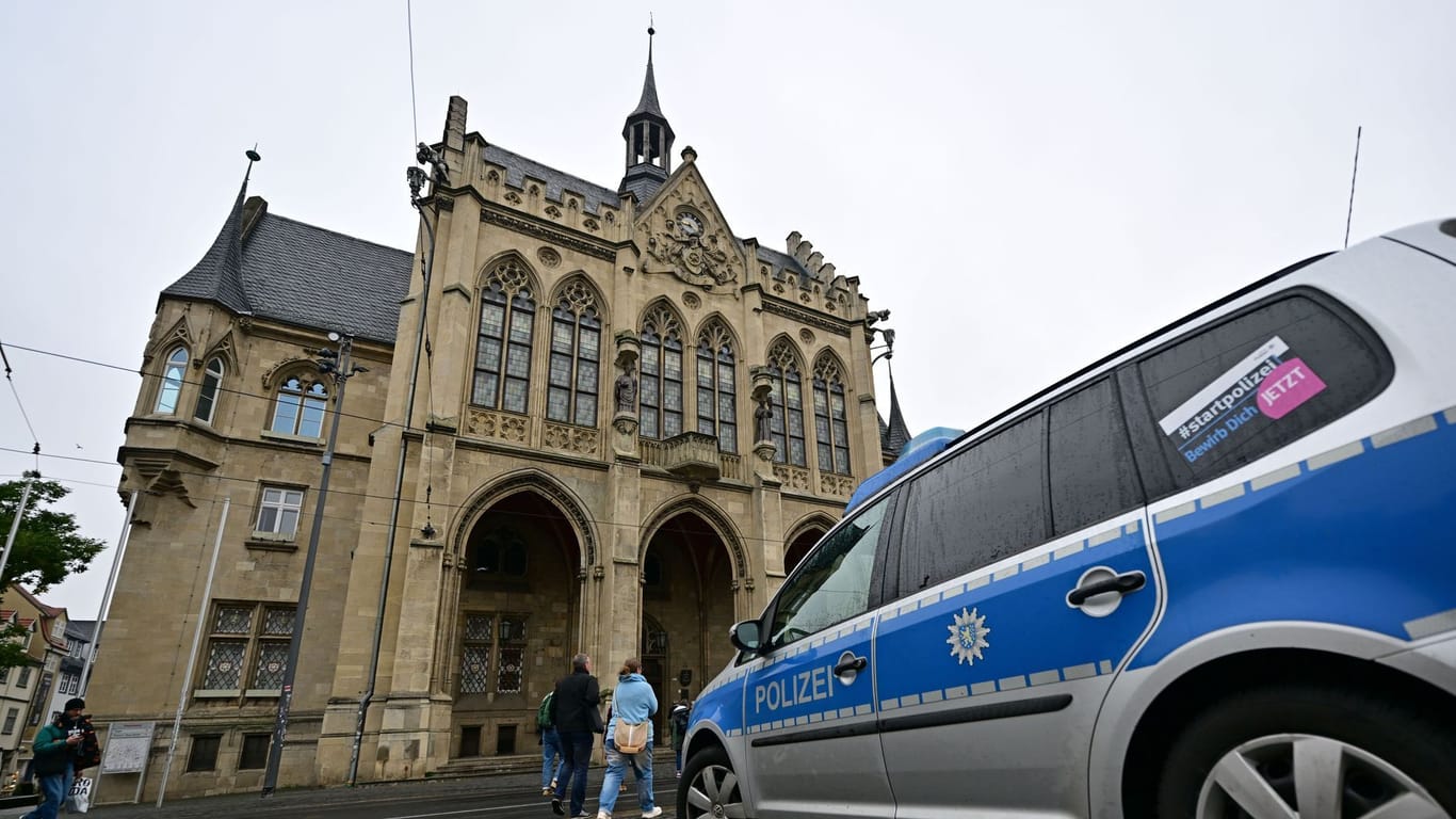 Ein Polizeiauto parkt nach der Bombendrohung vor dem Erfurter Rathaus. Was oder wer hinter den Drohungen steckt, ist bislang ungeklärt.