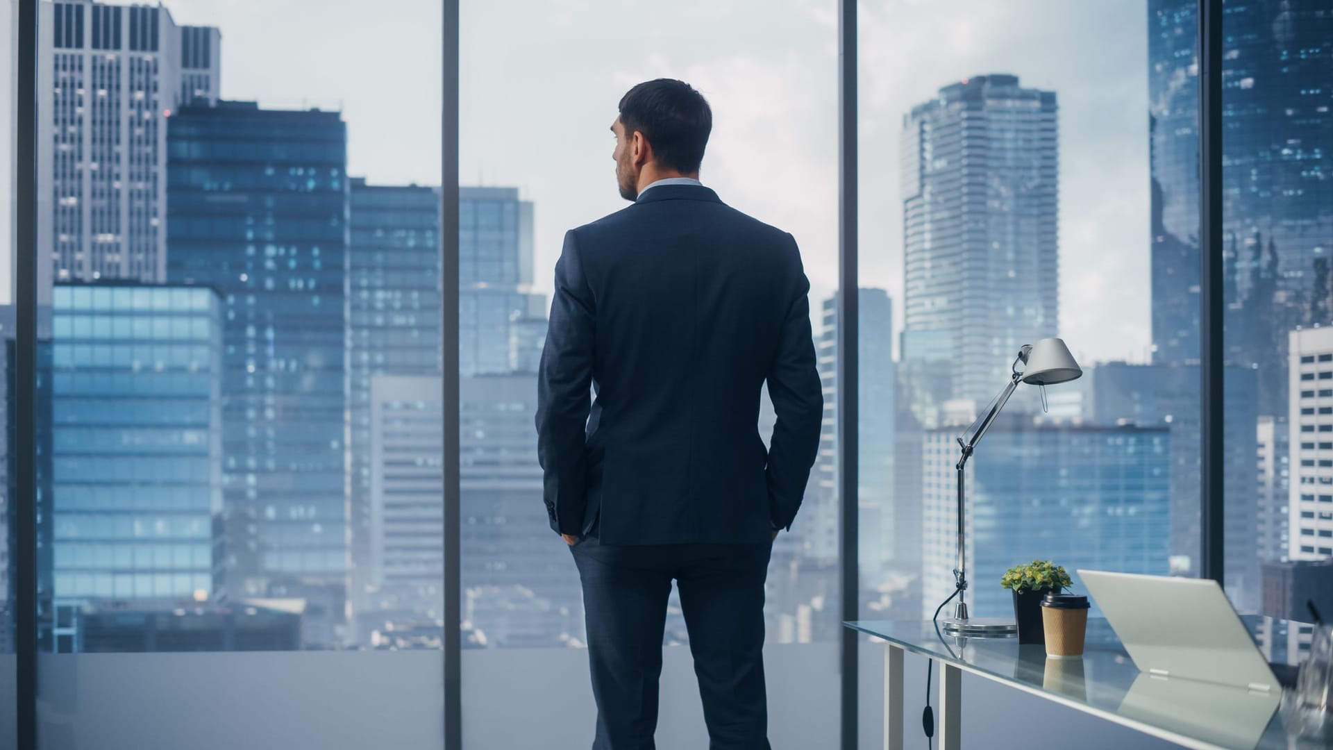 CEO schaut durchs Fenster auf die Skyline