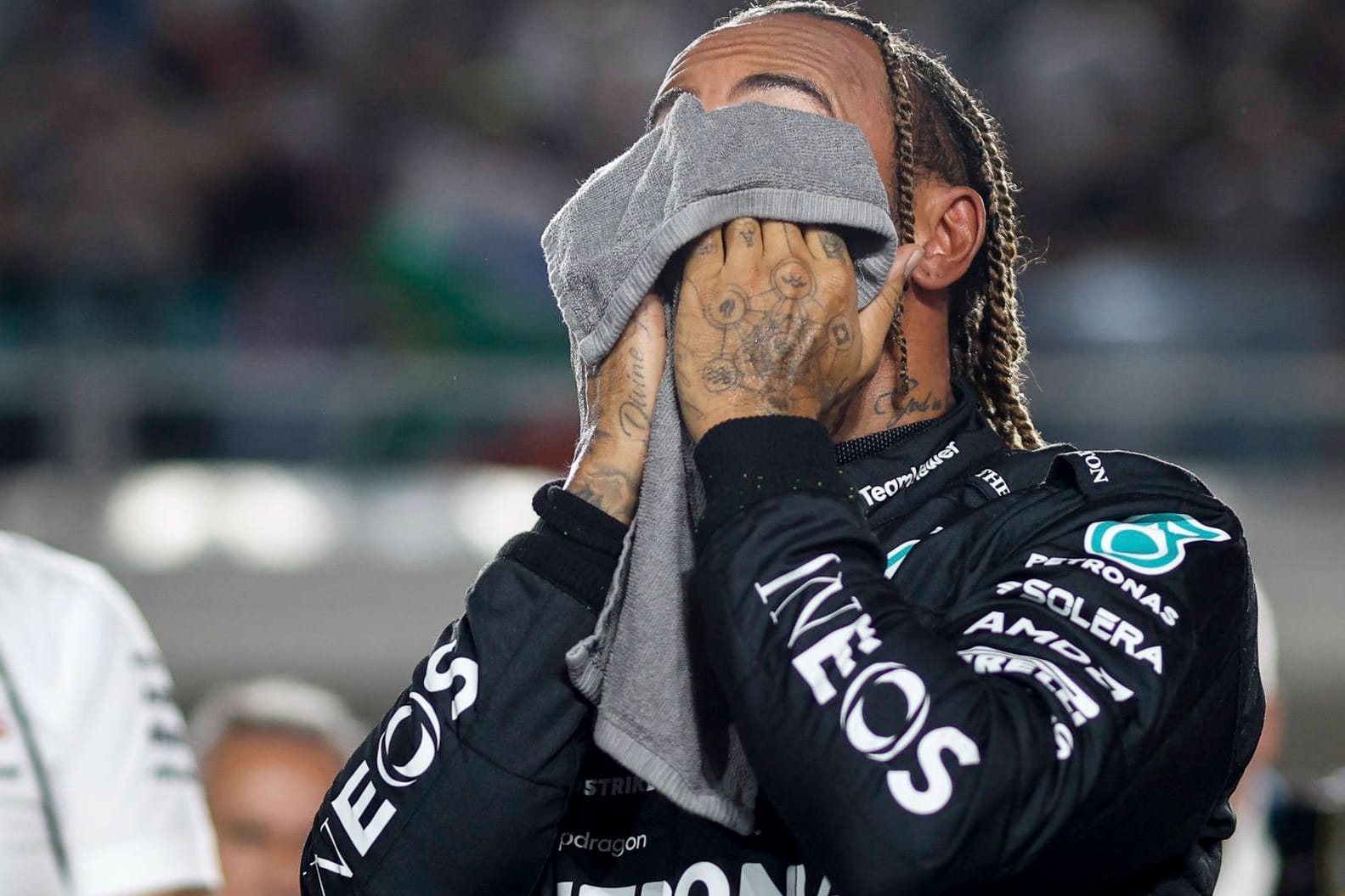 Lewis Hamilton trocknet sich das Gesicht ab: Die Bedingungen in Katar erschöpften die Fahrer.