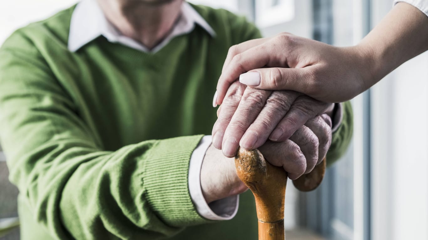 Eine Pflegerin hält die Hand eines Seniors (Symbolbild): Ein Mann gewann im Lotto. Von dem Gewinn sah er vor seinem Tod nichts.