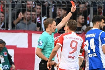 Hatte viel zu tun in der 1. Halbzeit: Schiedsrichter Petersen (li.) zeigt Bayerns Kimmich (verdeckt) die Rote Karte.