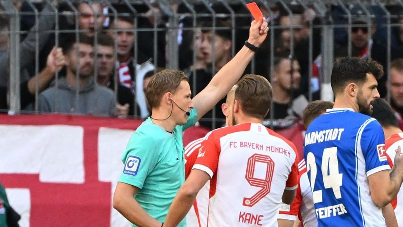 Hatte viel zu tun in der 1. Halbzeit: Schiedsrichter Petersen (li.) zeigt Bayerns Kimmich (verdeckt) die Rote Karte.