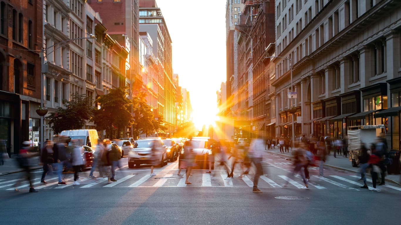 Menschen überqueren am Morgen bei Sonnenaufgang die Straße in New York
