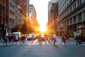 Menschen überqueren am Morgen bei Sonnenaufgang die Straße in New York