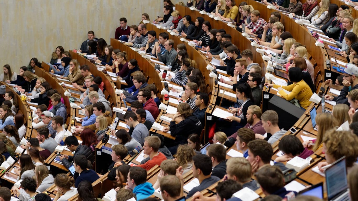 Studierende sitzen in einem Hörsaalgebäude (Symbolfoto): Der Semesterbeitrag setzt sich aus den Beiträgen für das Studierendenwerk und dem Semesterticket zusammen.