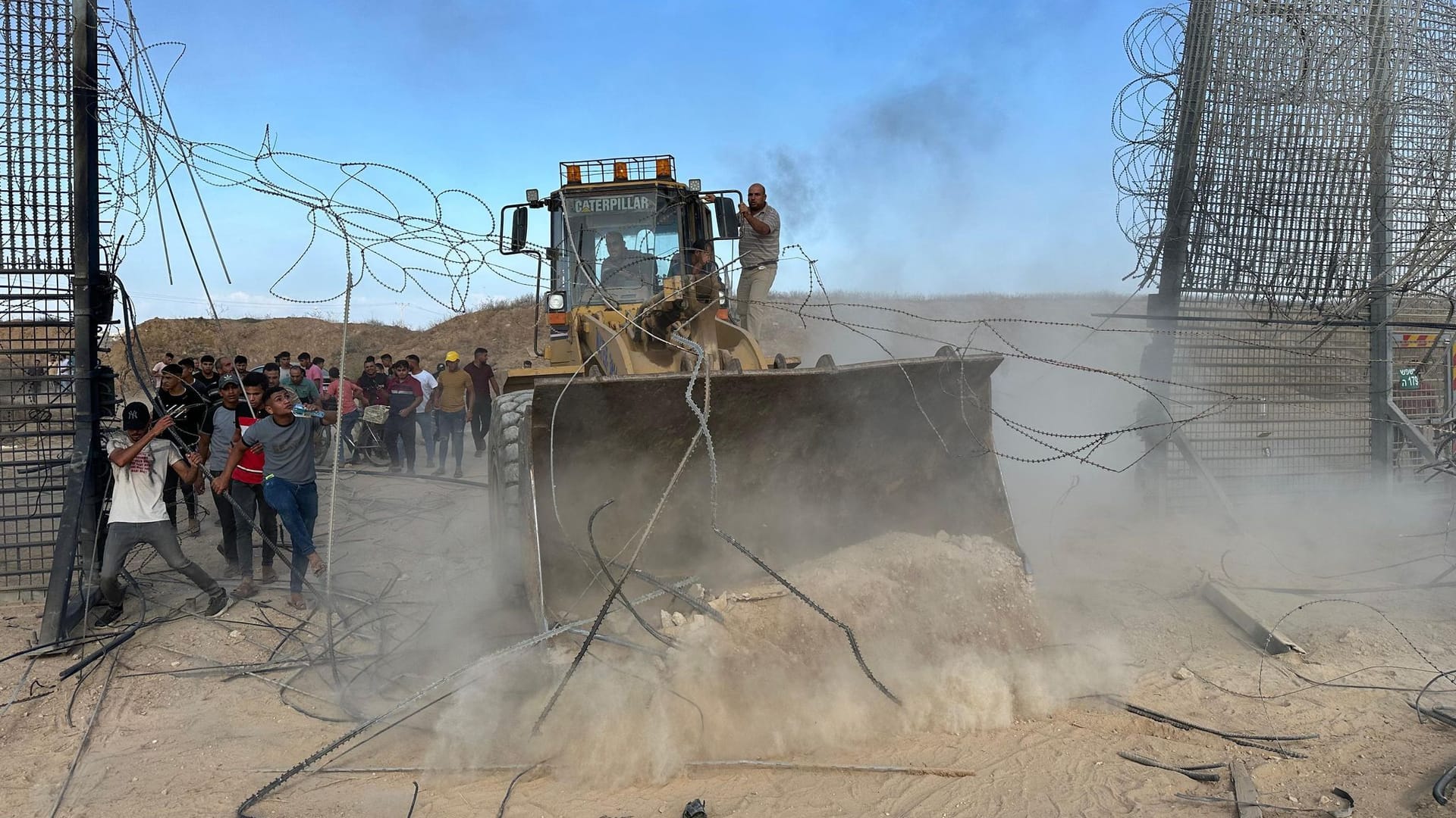 Hamas-Anhänger überqueren den Grenzzaun zu Israel in Khan Yunis im südlichen Gazastreifen mit einem Bagger: Wie es dazu kommen konnte, ohne dass der israelische Geheimdienst davon mitbekam, ist unklar.