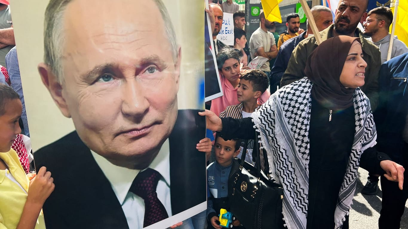 Palästinenser demonstrieren im Westjordanland und zeigen ein Porträt des russischen Machthabers Putin.