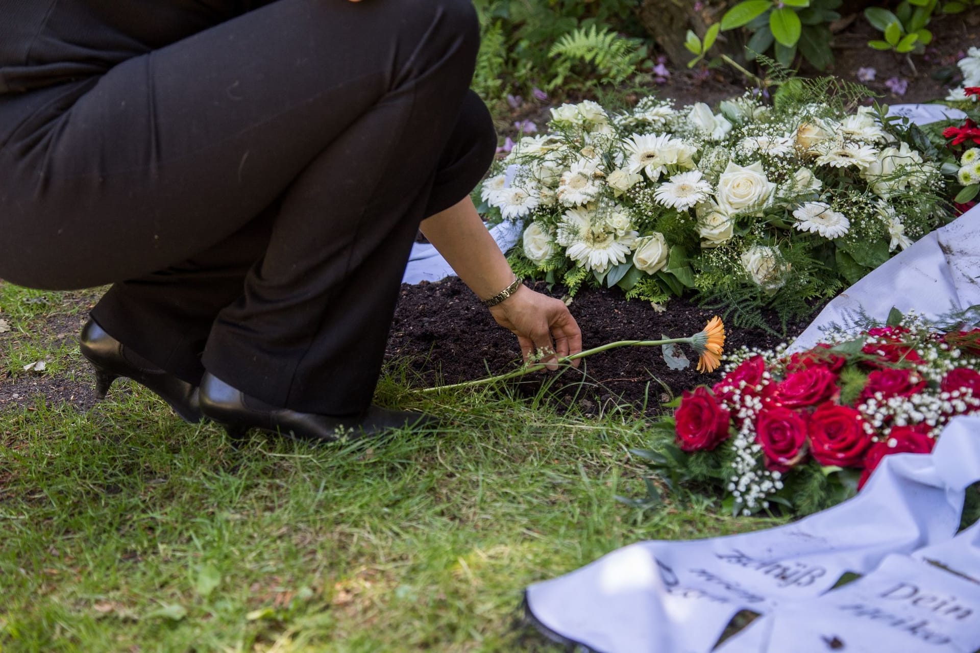 Eine Person legt Blumen nieder