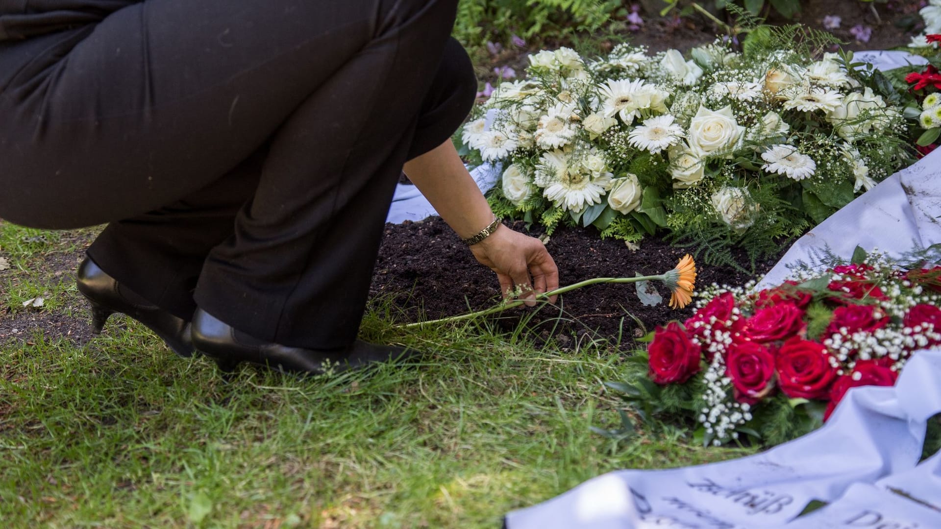 Eine Person legt Blumen nieder