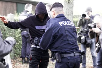 Ein Polizist tastet einen aufgegriffenen Flüchtling ab.