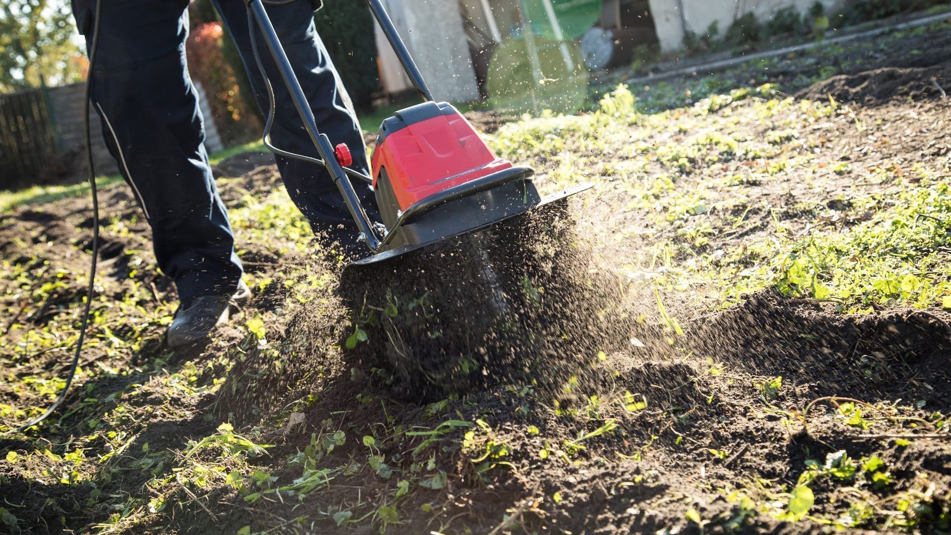 Eine Person bearbeitet Gartenboden