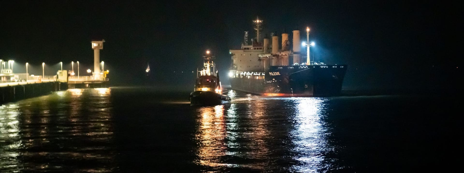 Cuxhaven: Das Frachtschiff «Polesie» wird in der Nacht von zwei Schleppern an den Kai der Seebäderbrücke gezogen.