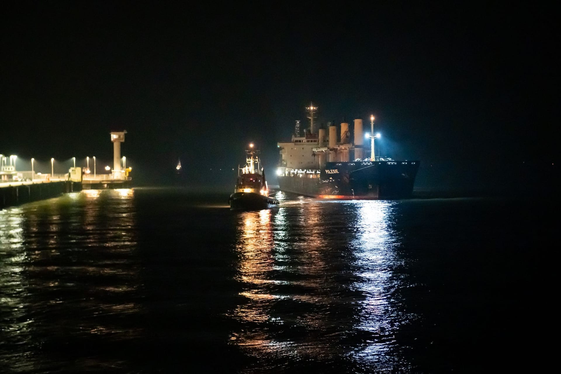 Cuxhaven: Das Frachtschiff «Polesie» wird in der Nacht von zwei Schleppern an den Kai der Seebäderbrücke gezogen.