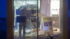 In Hessen werden von bislang unbekannten Tätern zwei Geldautomaten in einer Postbank-Filiale gesprengt. Das Bild zeigt einen Beamten bei den Ermittlungen in der zerfetzten Filiale.