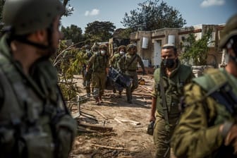 Israelische Streitkräfte bergen Leichen von israelischen Bewohnern aus einem zerstörten Haus.