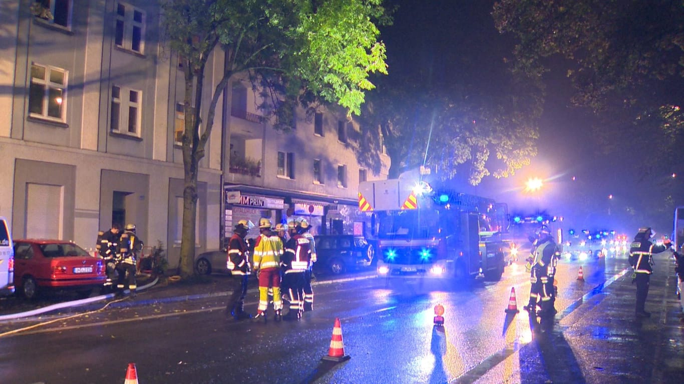 Einsatzkräfte sperren die Schützenstraße ab. Die Polizei geht bei einem Feuer eines Mehrfamilienhauses in Dortmund von Brandstiftung aus.