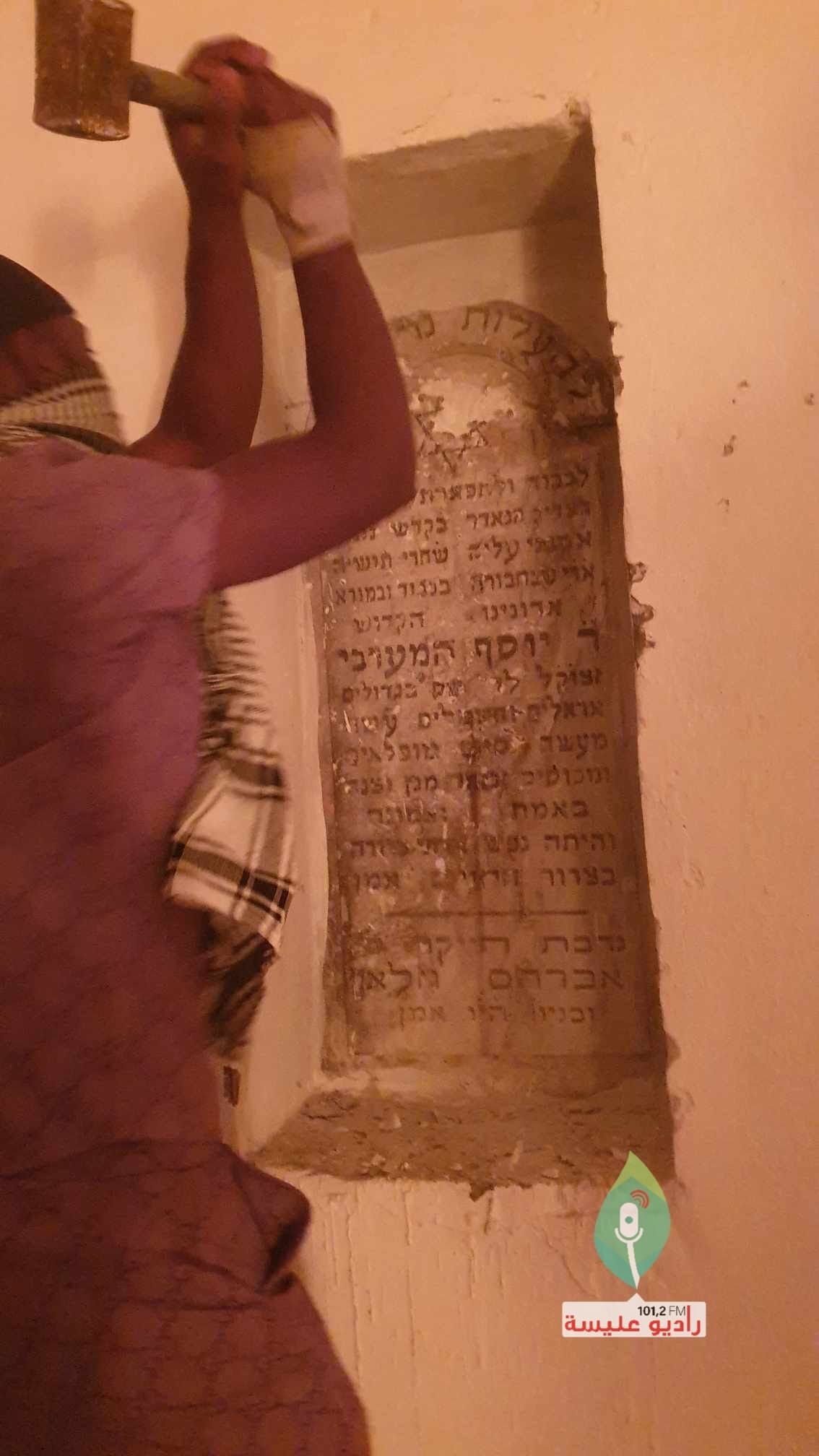 Ein Mann zerstört eine Schrifttafel in hebräischer Schrift in der El-Hamma-Synagoge: Aktiv genutzt wird das jüdische Gotteshaus nicht mehr.