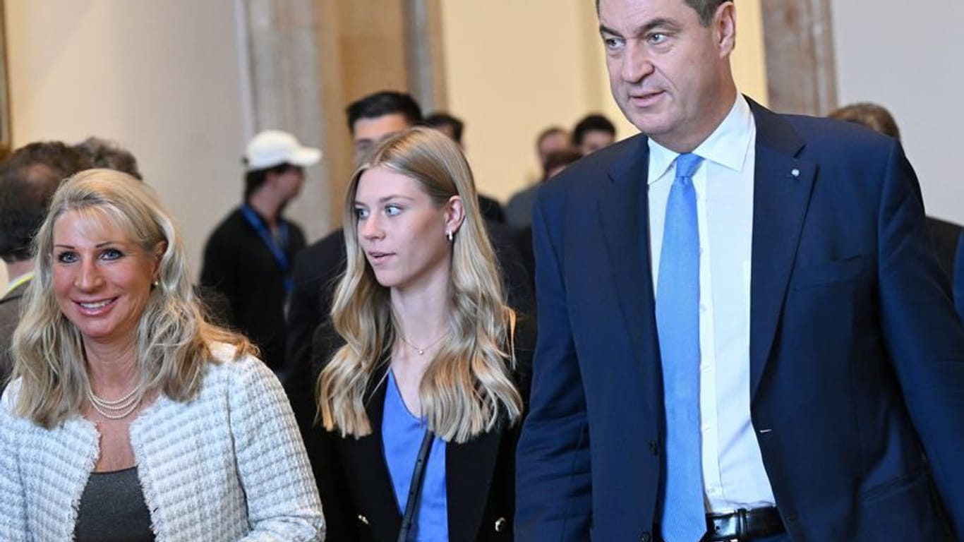 Markus Söder (CSU) kommt mit seiner Frau Karin Baumüller-Söder (l) und Tochter Selina zur Plenarsitzung.